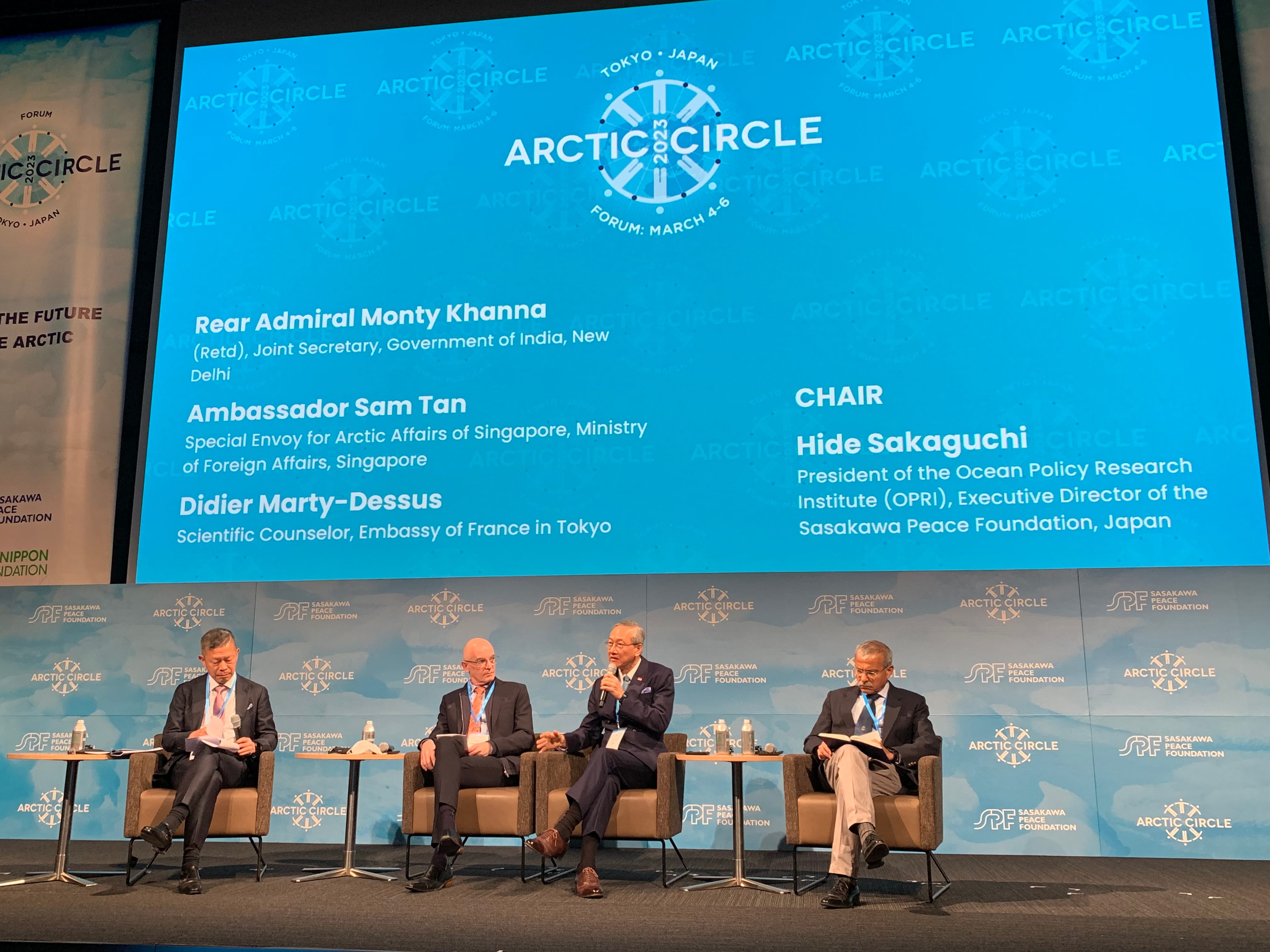 People at a meeting table with Singapore, Austria, and EU flags behind them.